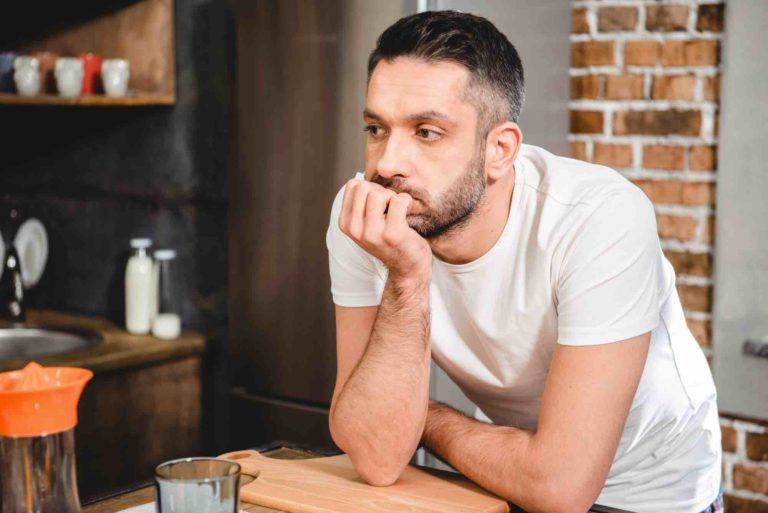 Mann lehnt am Tisch weil er keine Mietkaution erhalten hat