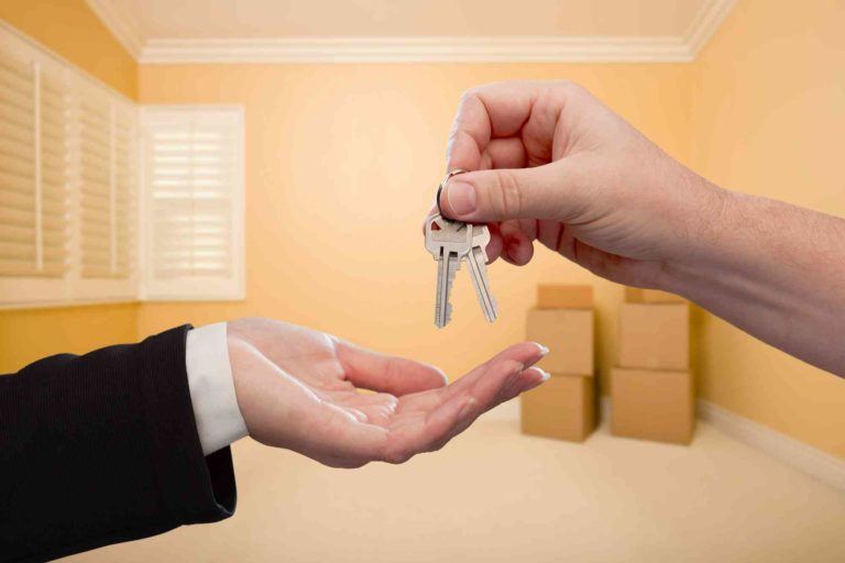 Hand hält Wohnungsschlüssel, die zurückgegeben werden